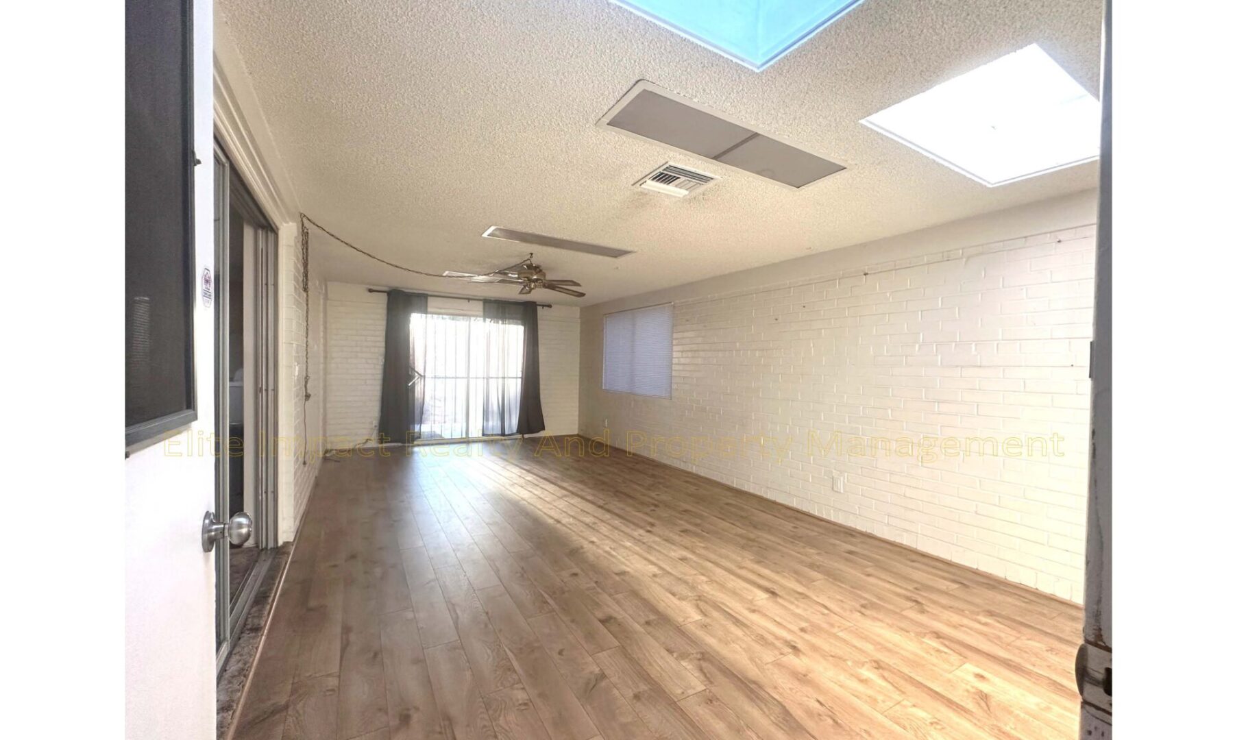 Empty room with wooden floor and skylights.