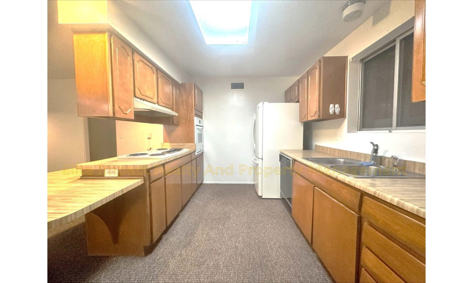 Bright kitchen with wooden cabinets and white appliances.