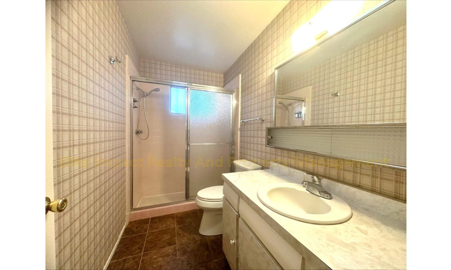 Bright bathroom with glass shower and single sink vanity.