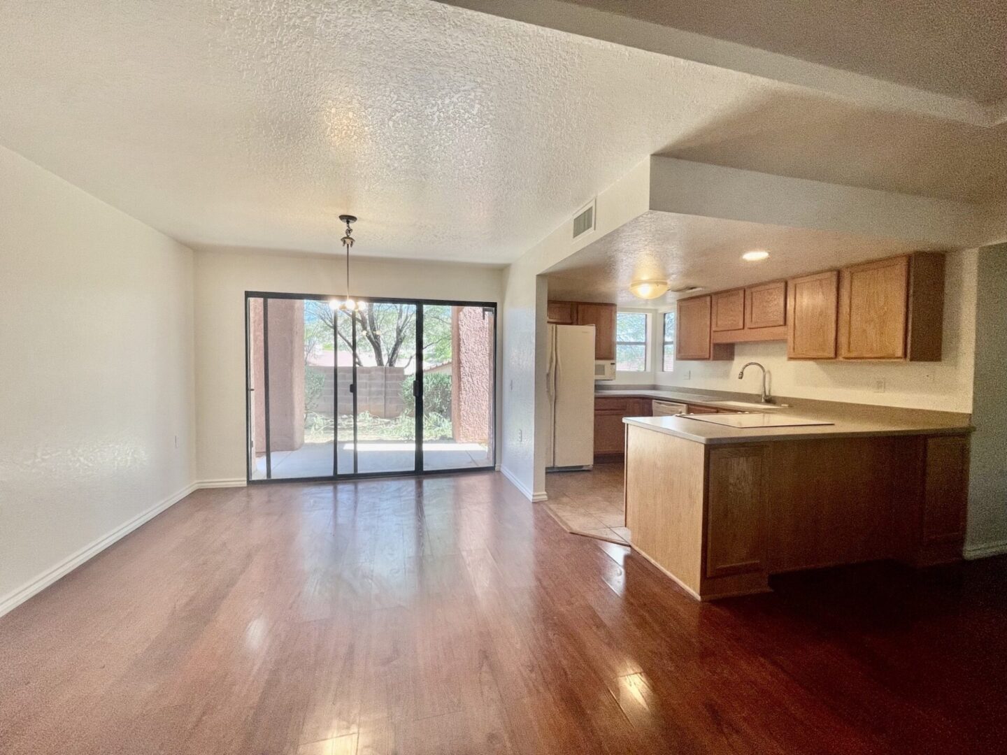 Spacious open-concept living area with hardwood floors and kitchen.