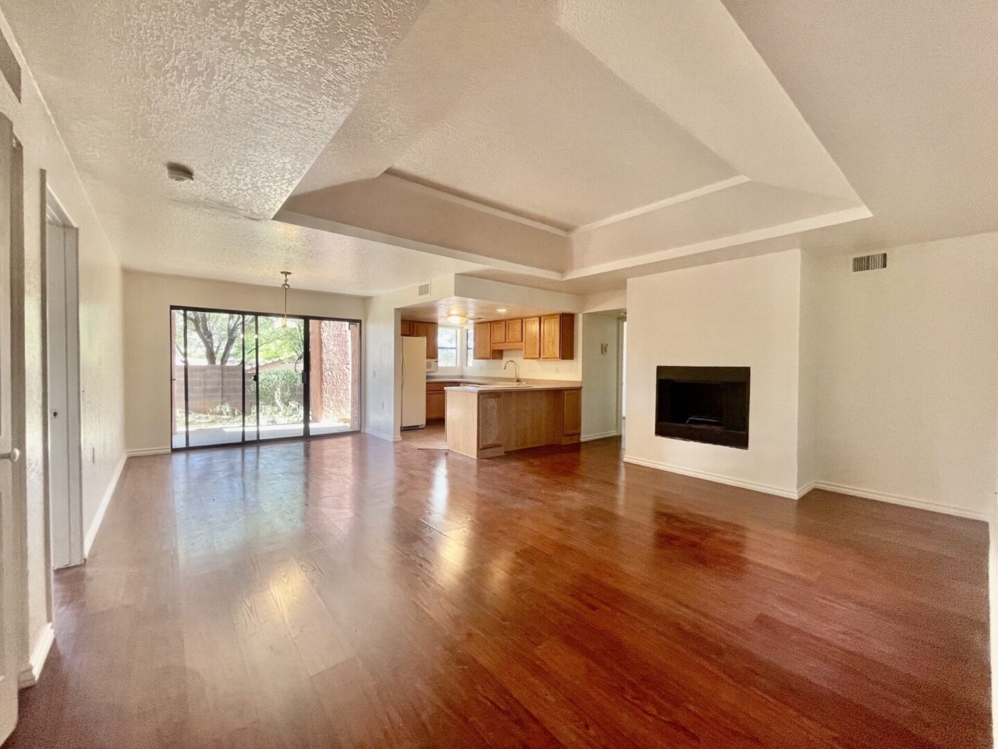 Spacious living room with hardwood floors and fireplace.