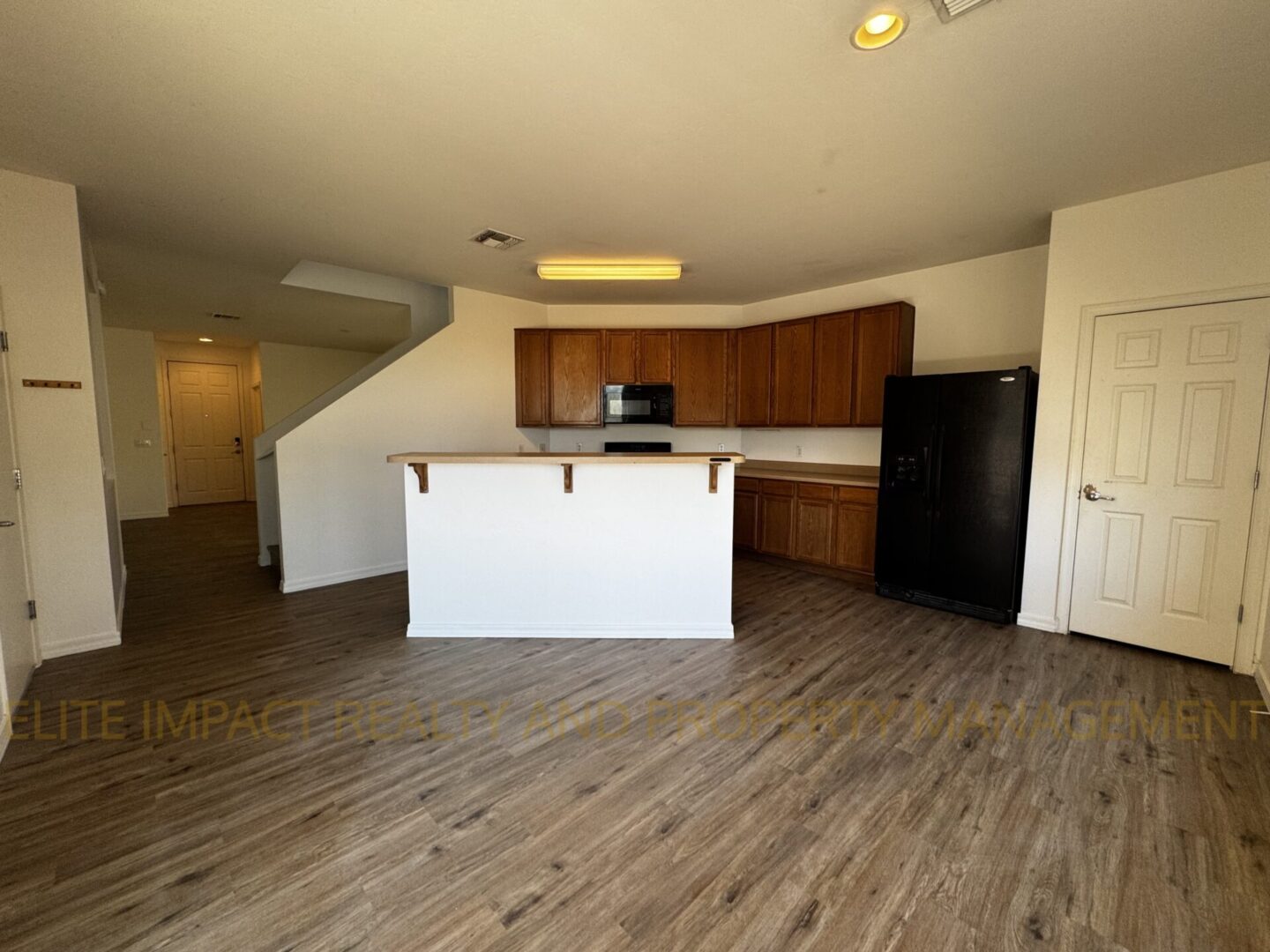 Modern kitchen with wooden cabinets and an island in an open floor plan.