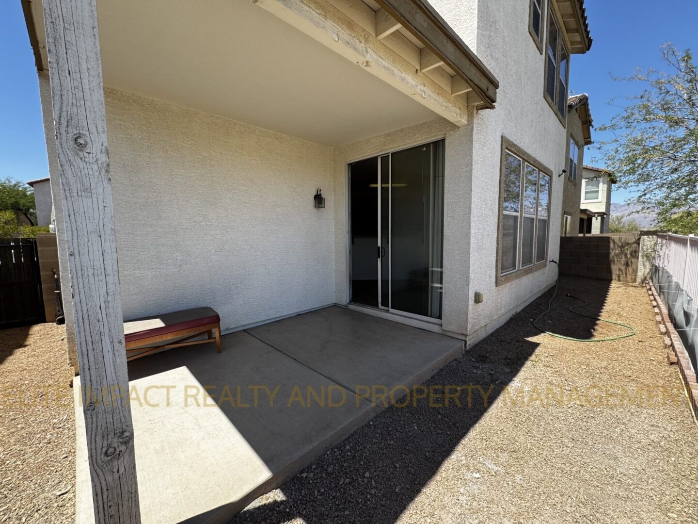 Empty concrete porch with sliding glass door on a sunny day.