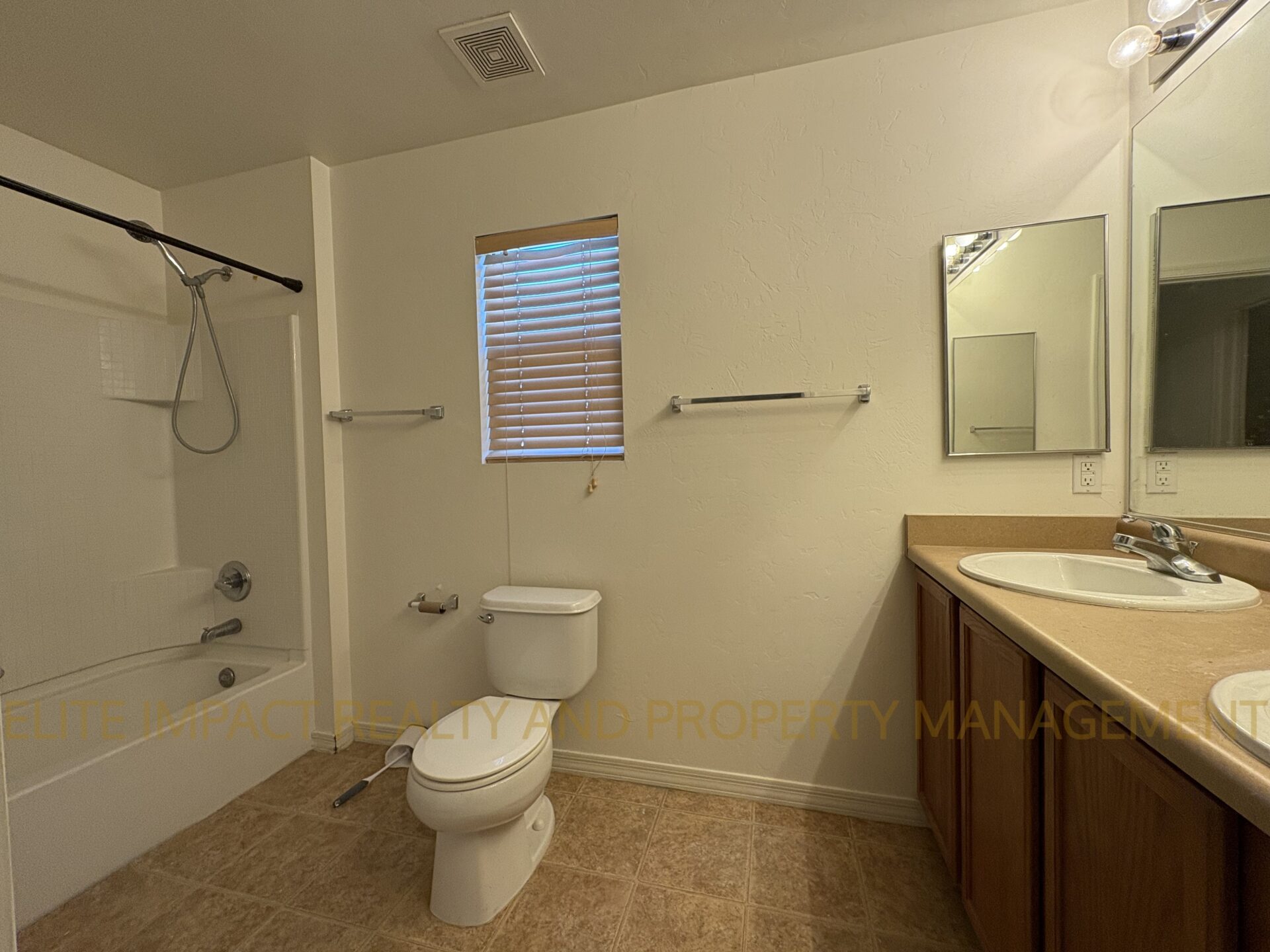 Simple bathroom with toilet, sink, mirror, and bathtub.