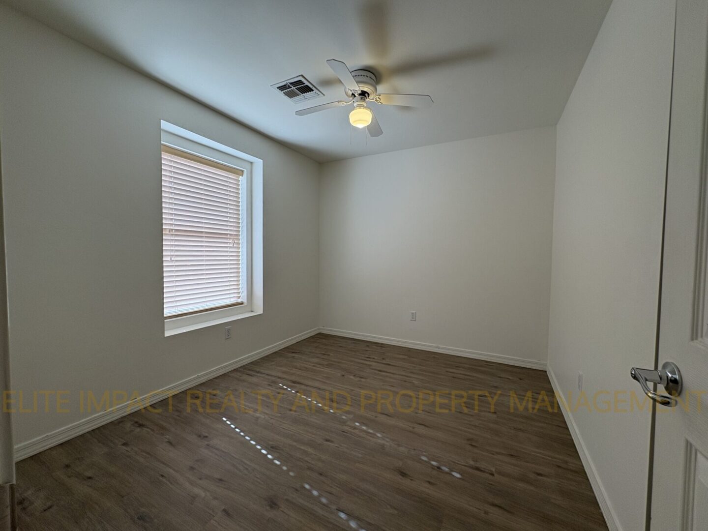 Empty room with wooden floor, ceiling fan, and window.