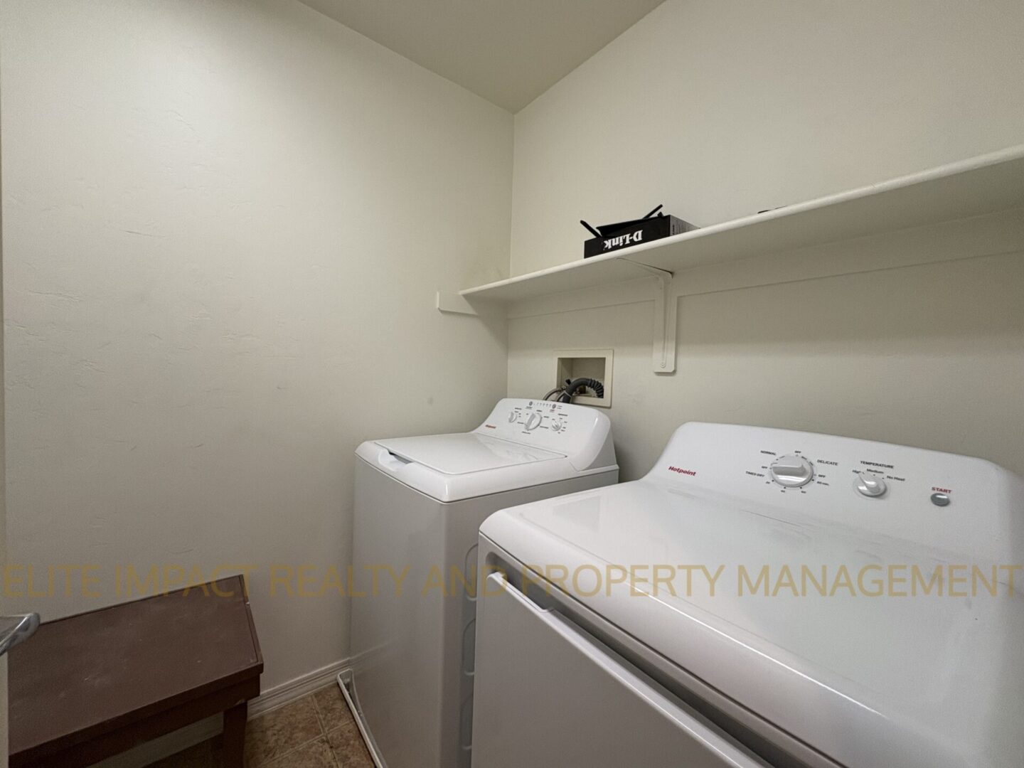 Laundry room with washer, dryer, and a small wooden bench.