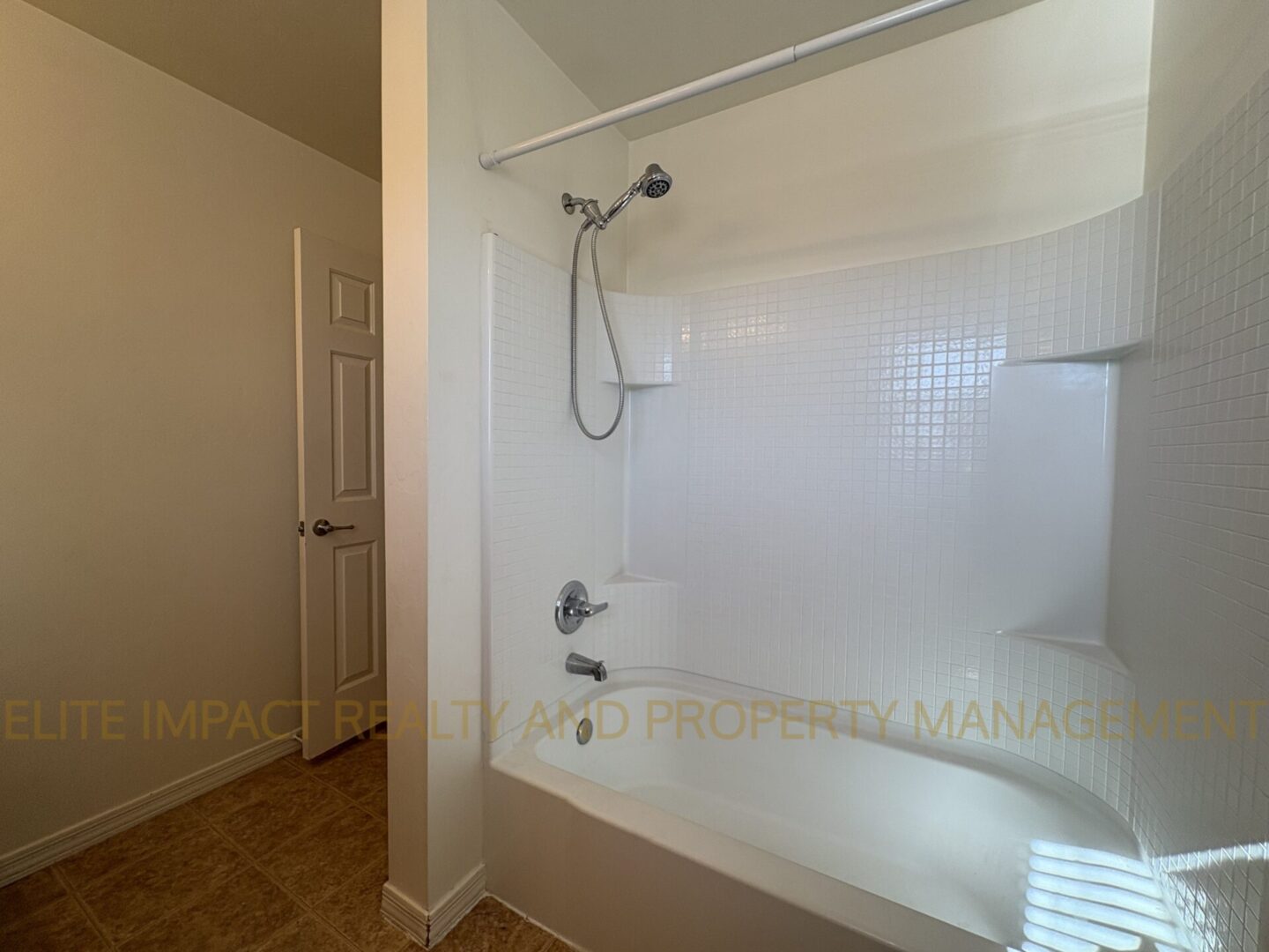 Clean white bathtub with showerhead in a bathroom.